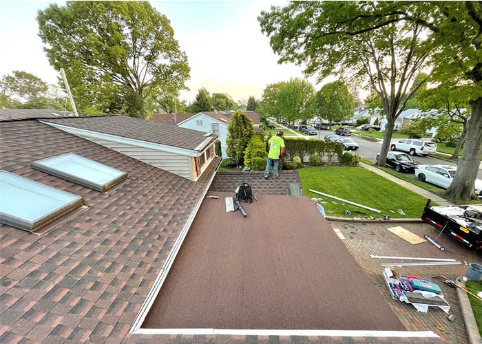 Crew installing a new roof with skylights on a Long Island ranch house
