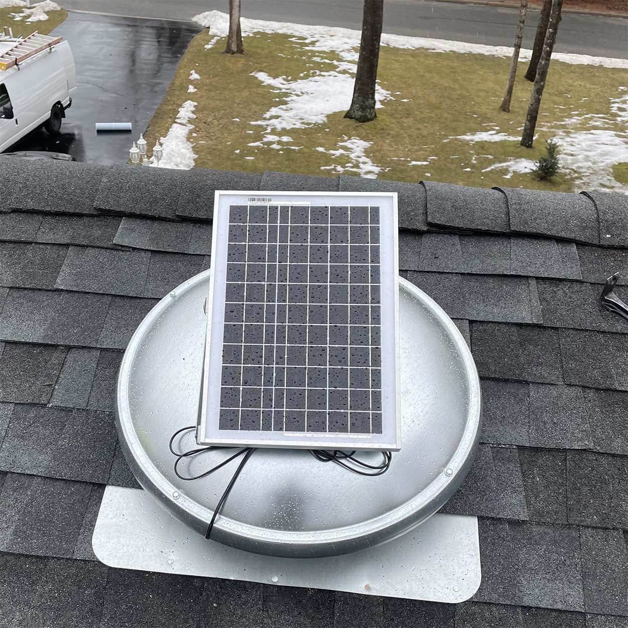 Solar-powered attic fan installed on a shingle roof